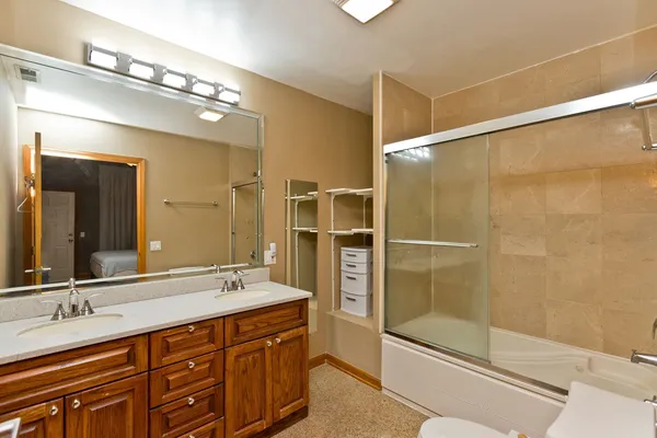 a bathroom with a double vanity sink mirror and shower