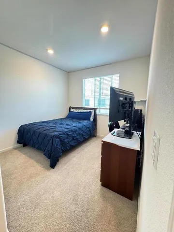 a spacious bedroom with a bed and a flat screen tv