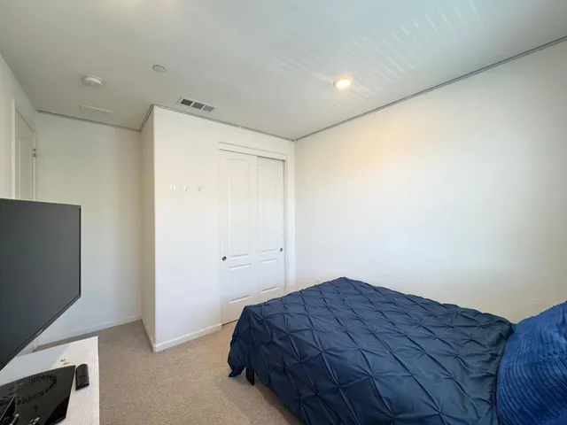 a bedroom with a bed and a flat screen tv