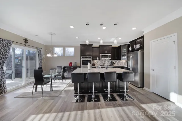 a kitchen with a dining table chairs and white appliances