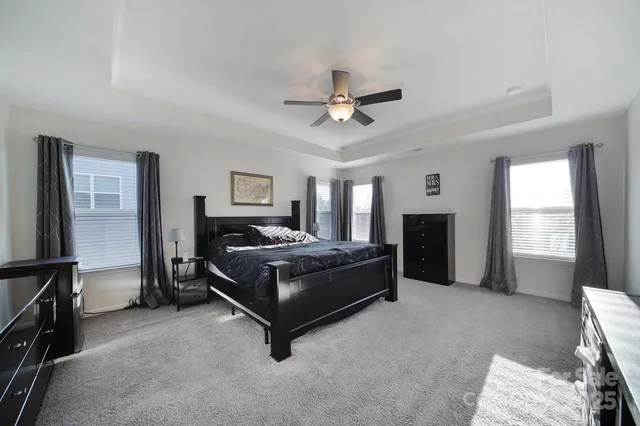 a spacious bedroom with a bed and a chandelier