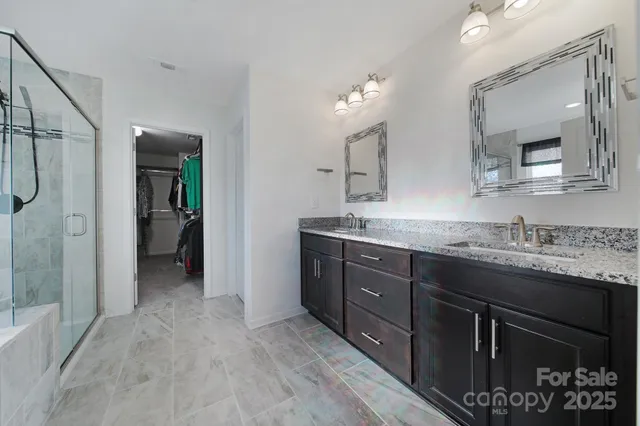 a bathroom with a granite countertop sink vanity and mirror