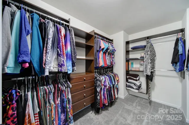 a view of walk in closet with clothes