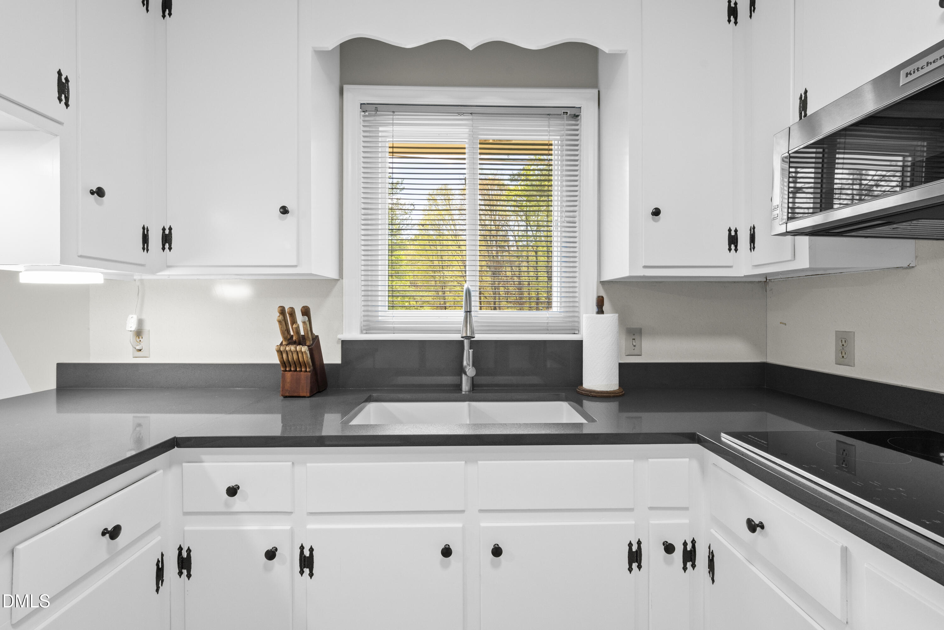 518 Goodwin Road Durham, NC 27712 - Photo 7 of 38 a kitchen with granite countertop white cabinets and window