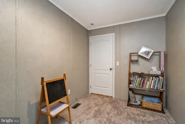 a view of an empty room and bathroom with a workspace