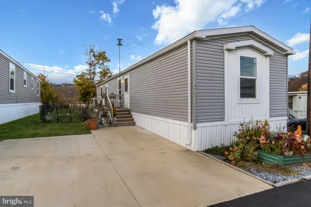 a view of a house with a yard and potted plants