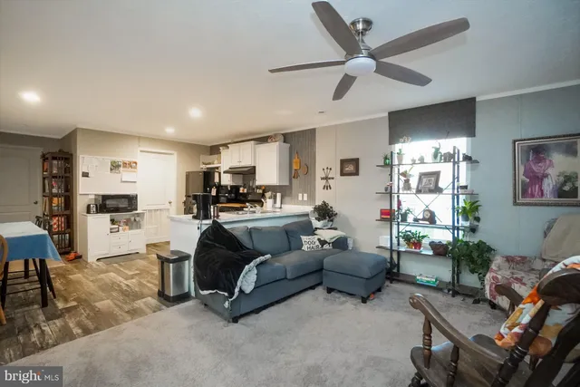 a living room with furniture kitchen view and a window