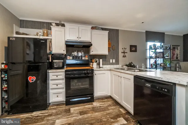 a kitchen with granite countertop a refrigerator stove and sink