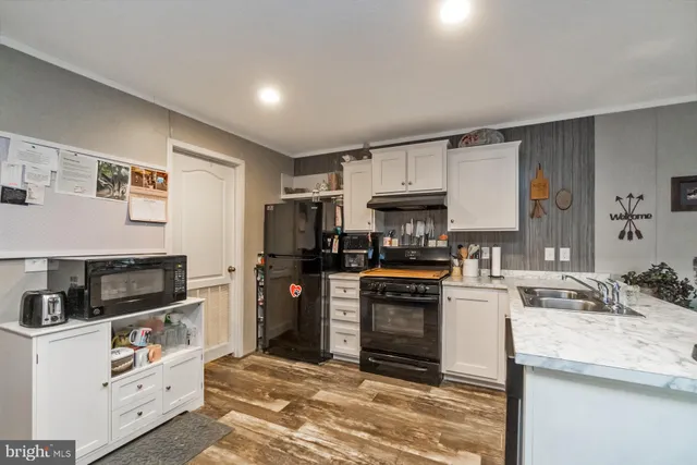 a kitchen with granite countertop a sink stove and refrigerator