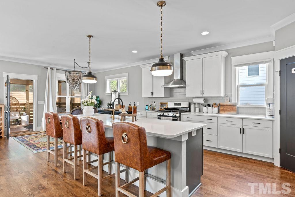 607 Bragg Street Raleigh, NC 27610 - Photo 11 of 44 a large kitchen with granite countertop lots of white cabinets appliances and furniture