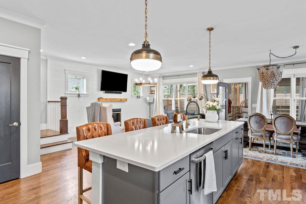 607 Bragg Street Raleigh, NC 27610 - Photo 15 of 44 a kitchen with stainless steel appliances granite countertop a sink a stove and a wooden floor