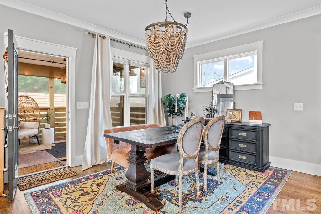 607 Bragg Street Raleigh, NC 27610 - Photo 17 of 44 a dining room with furniture a chandelier and wooden floor