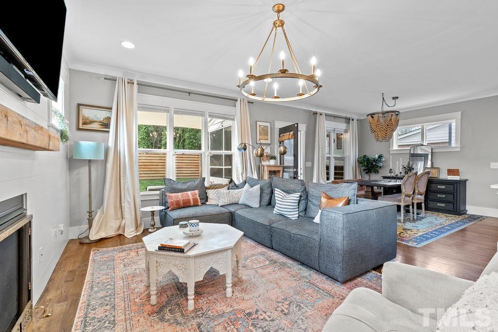 607 Bragg Street Raleigh, NC 27610 - Photo 20 of 44 a living room with furniture a dining table and a chandelier