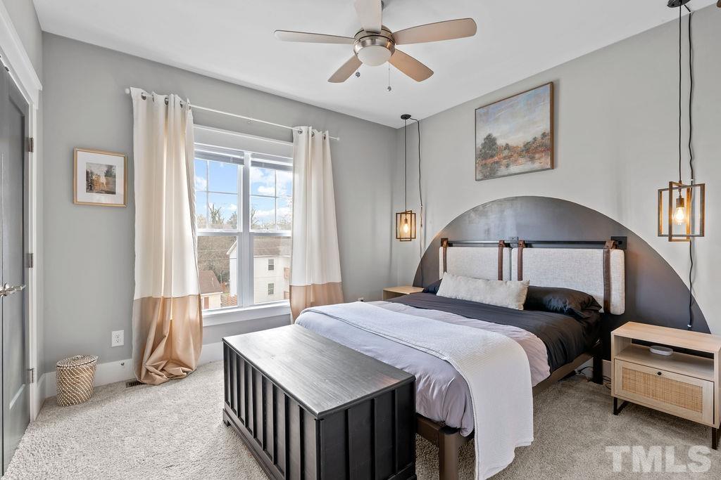 607 Bragg Street Raleigh, NC 27610 - Photo 28 of 44 a bedroom with a bed and a chandelier