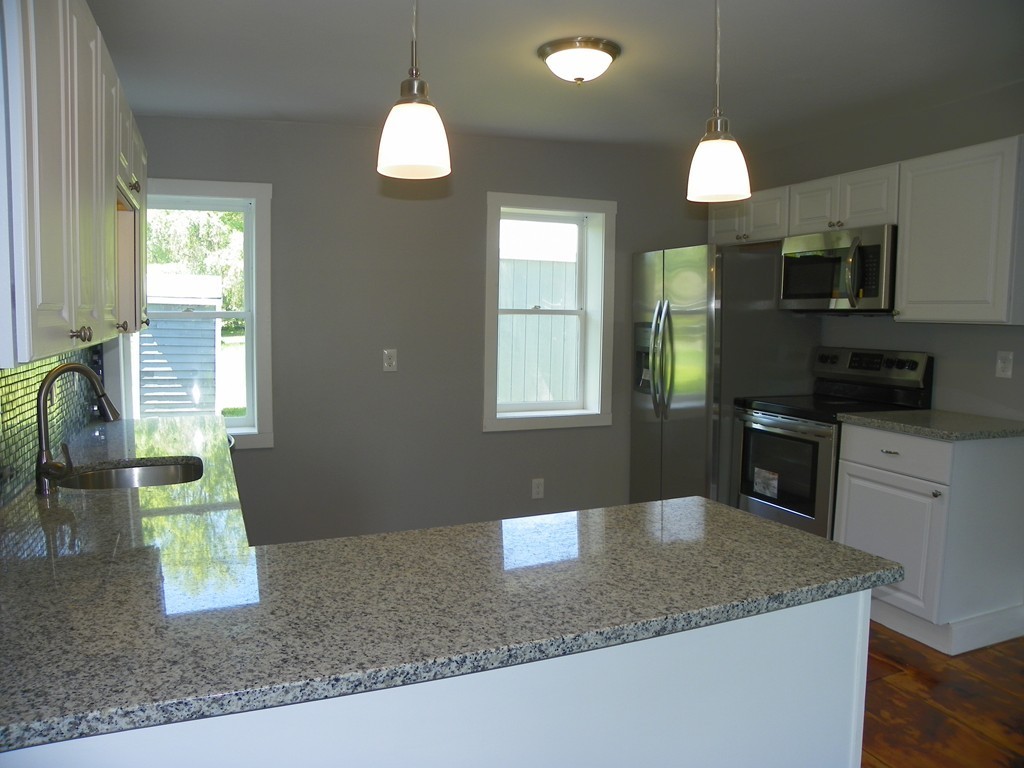 4 Gardner Road Hubbardston, MA 01452 - Photo 6 of 22 a kitchen with stainless steel appliances granite countertop a sink a microwave oven a stove with granite countertops and cabinets