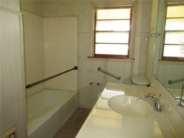 a bathroom with a tub a sink and a window