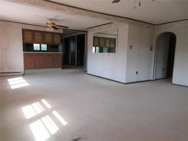 a view of empty room with kitchen