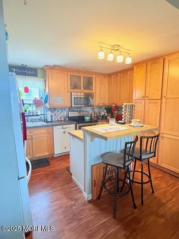 a kitchen with stainless steel appliances granite countertop a table chairs sink and cabinets