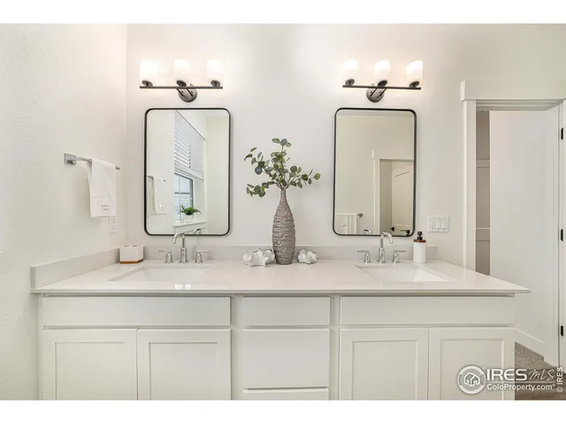 a bathroom with double vanity sinks and a mirror
