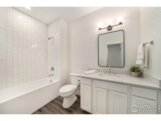 a bathroom with a granite countertop sink toilet a large mirror a bathtub and shower