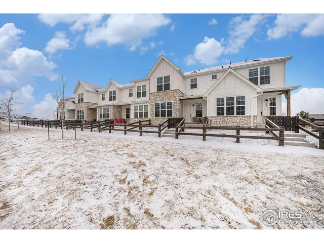 a view of a white house with a yard in the background