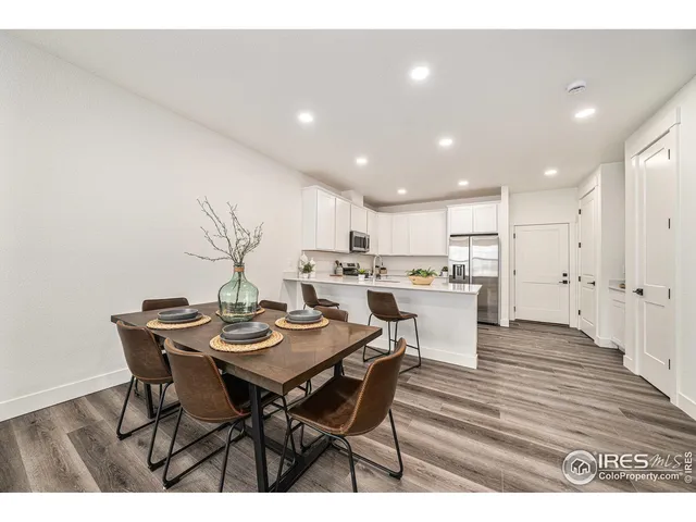a open dining room with stainless steel appliances kitchen island a table and chairs