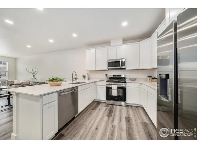 a kitchen with white cabinets appliances and sink