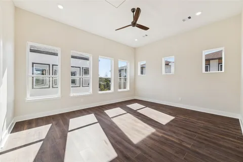 a view of an empty room with a window and wooden floor