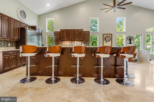 a large room with stainless steel appliances lots of white furniture a rug kitchen view and a counter top space