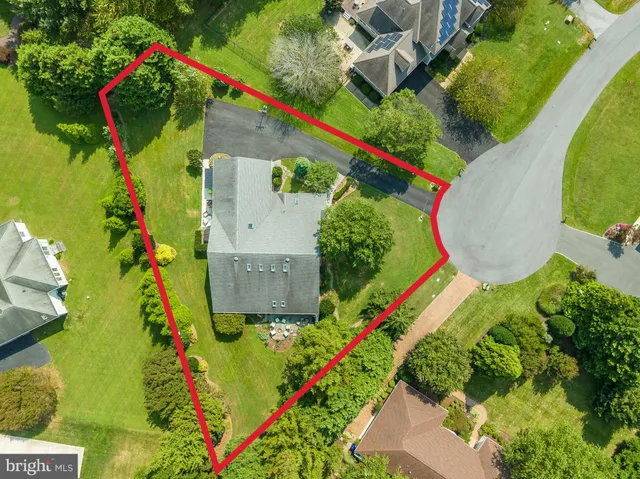 an aerial view of a house with a yard and lake view