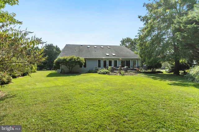 a living room with furniture a wooden floor and next to a window