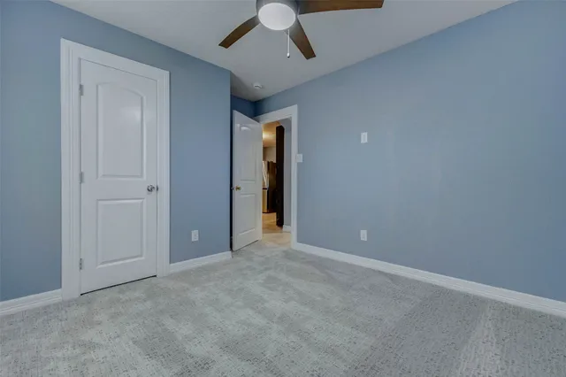 an empty room with chandelier fan