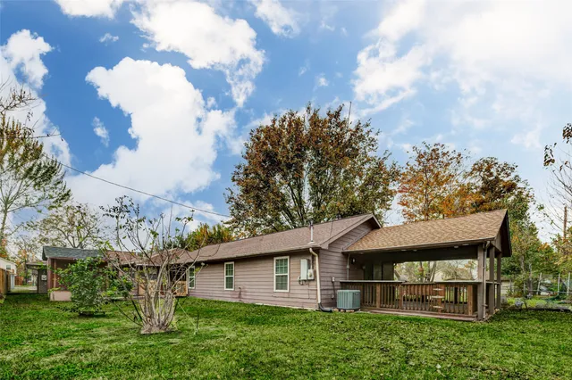 a view of a house with a big yard plants and large trees