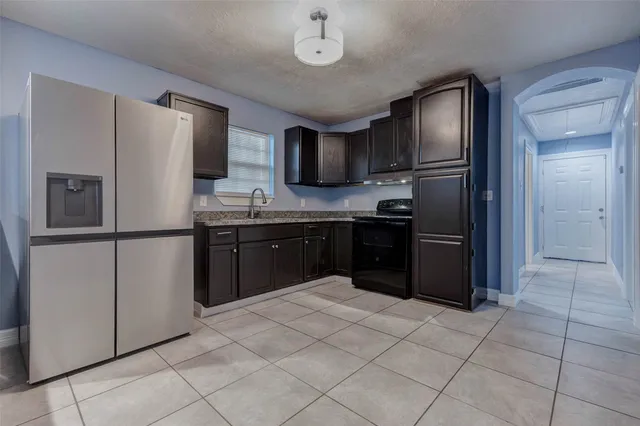 a kitchen with stainless steel appliances granite countertop a refrigerator and a sink