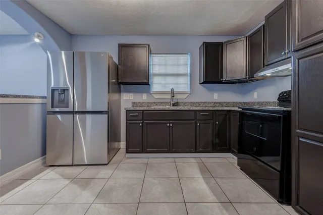 a kitchen with stainless steel appliances granite countertop a refrigerator and a sink