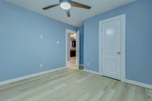 an empty room with closet and a chandelier fan