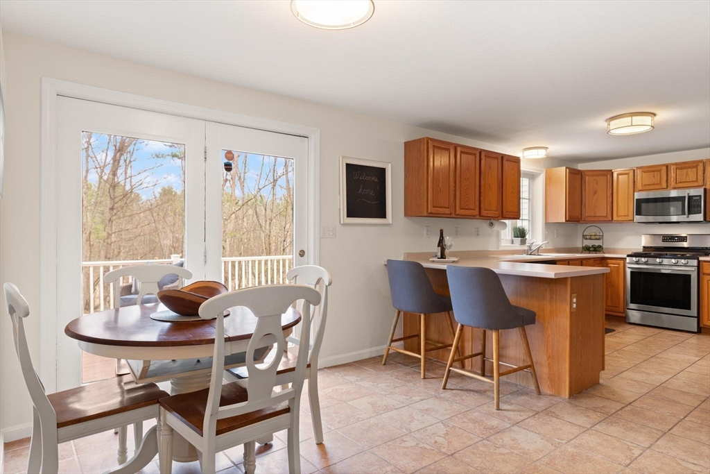 41 Chestnut Road Tyngsborough, MA 01879 - Photo 9 of 32 a living room with granite countertop furniture a dining table and a microwave