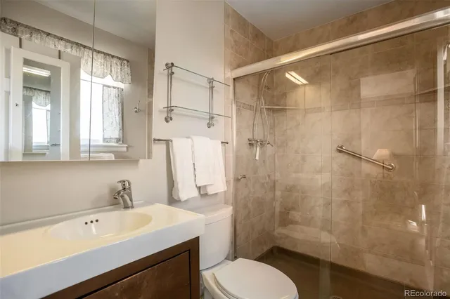 a bathroom with a sink toilet a mirror and shower