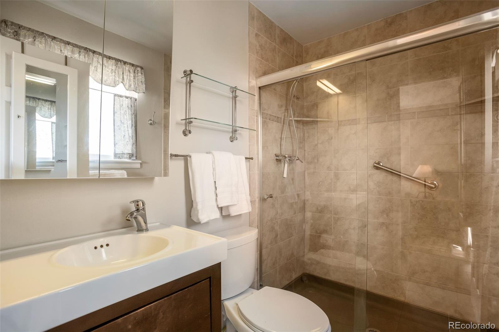 8678 Lariat Loop Elizabeth, CO 80107 - Photo 25 of 50 a bathroom with a sink toilet a mirror and shower