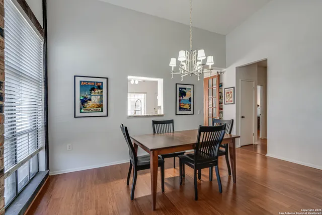 a view of a dining room with furniture a chandelier and wooden floor