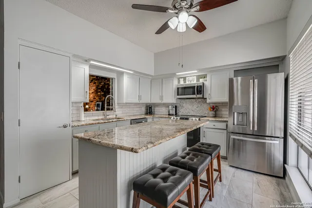 a kitchen with stainless steel appliances granite countertop a sink refrigerator and microwave