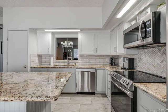 a kitchen with stainless steel appliances granite countertop a sink and a stove
