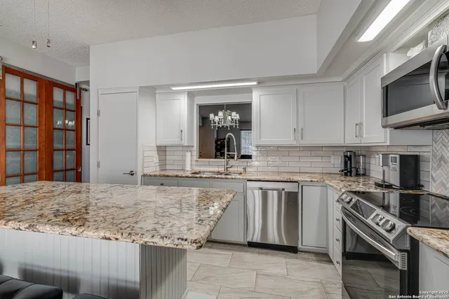 a kitchen with stainless steel appliances granite countertop a stove and a sink