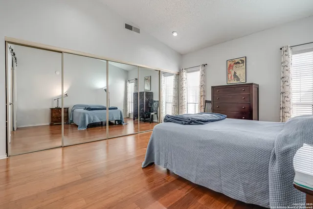 a spacious bedroom with a bed and wooden floor