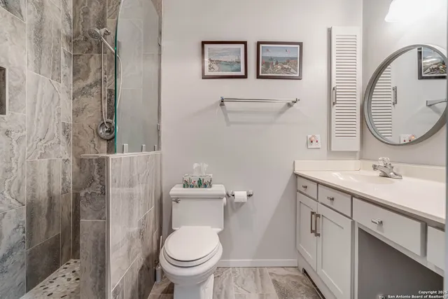 a bathroom with a toilet sink vanity and mirror