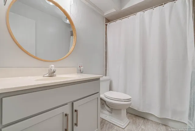 a bathroom with a sink a toilet and a mirror