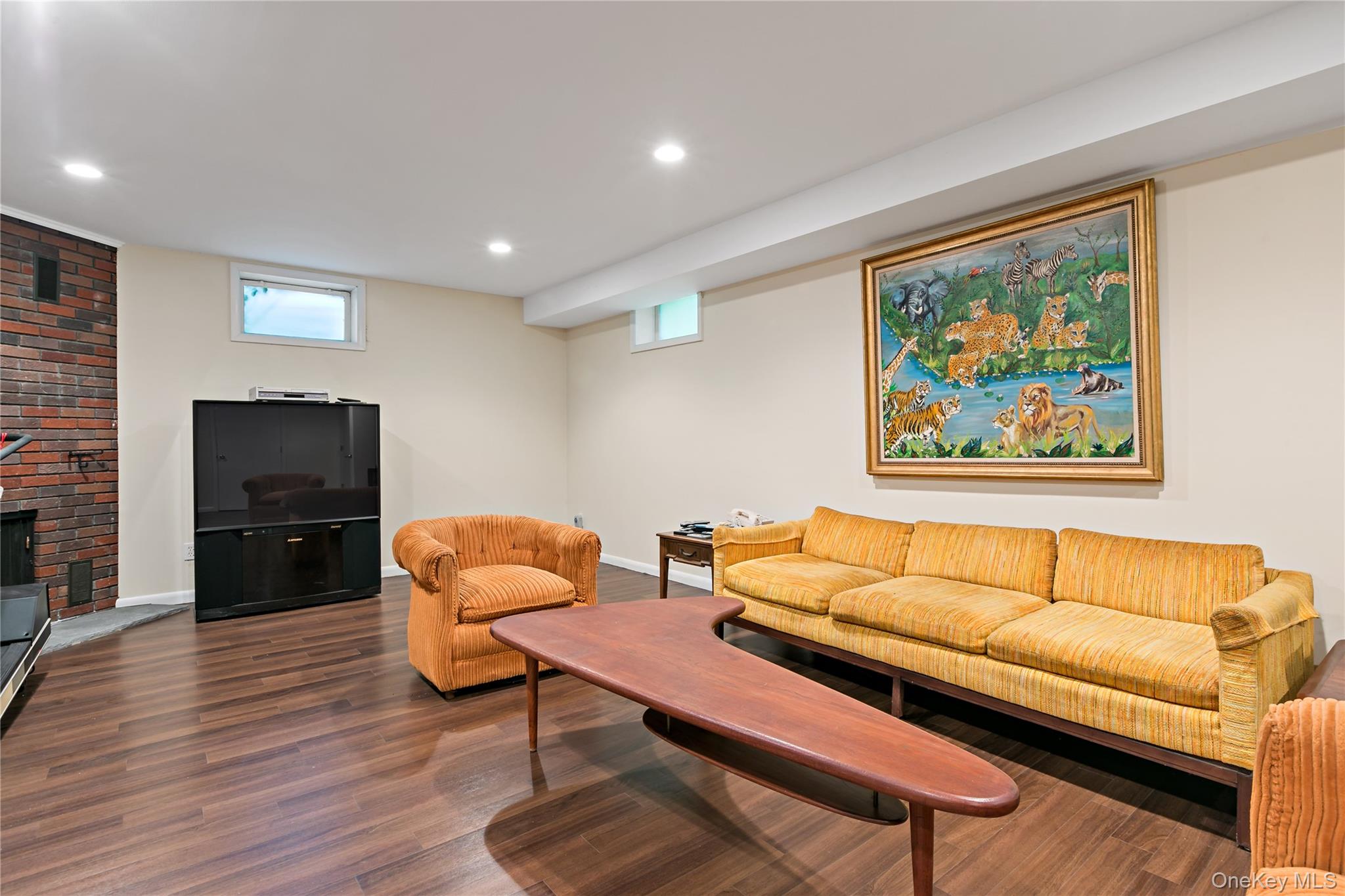 16 Meadow Road Scarsdale, NY 10583 - Photo 30 of 47 a living room with furniture a flat screen tv and a fireplace