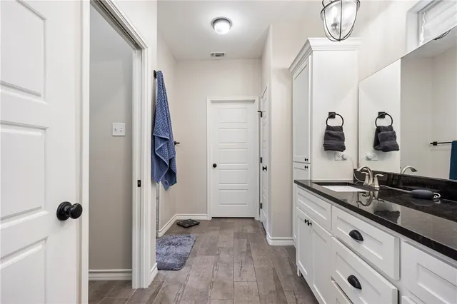 a bathroom with a granite countertop sink a mirror a vanity and a shower