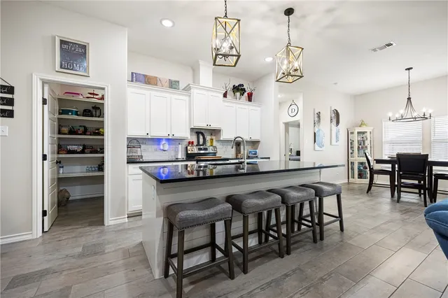 a very nice looking dining room with kitchen island stainless steel appliances a table and chairs