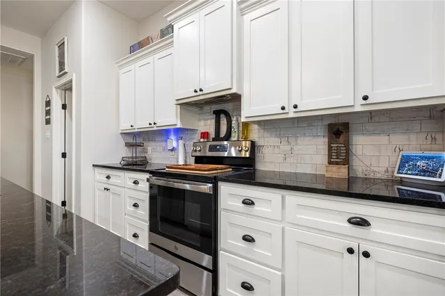 a kitchen with granite countertop white cabinets and white appliances